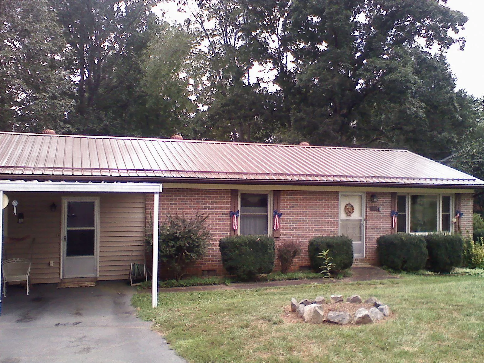 Bronze metal roof and carport on a brick ranch home — Roof Repair work by our crew in Madera