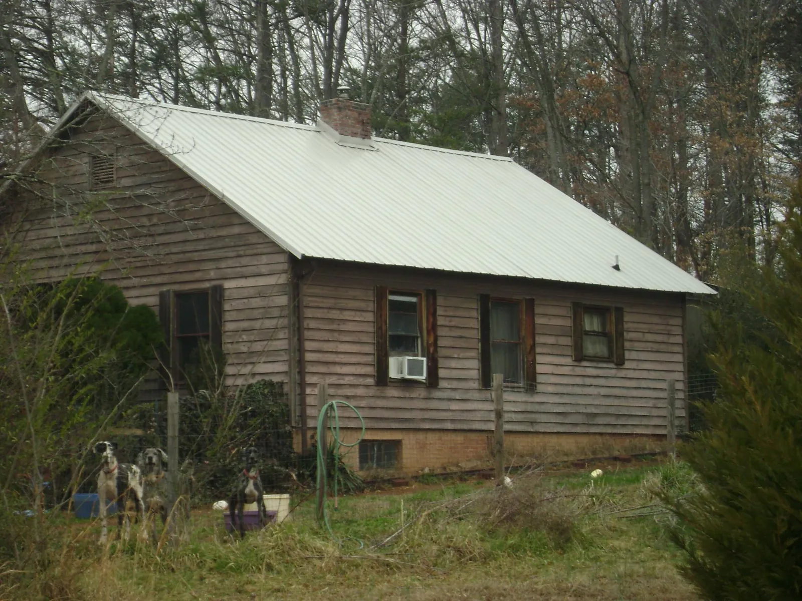 White metal roof on an old wood sided farmhouse, from a Metal Roof Installation job in Madera